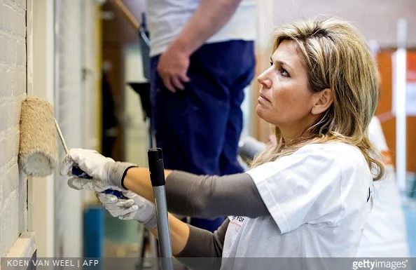 Dutch Queen Maxima paints a wall in the sports area of a cultural centre in the village Tricht, on March 21, 2015. Members of the Dutch royal family take part in the national voluntary event NLdoet.