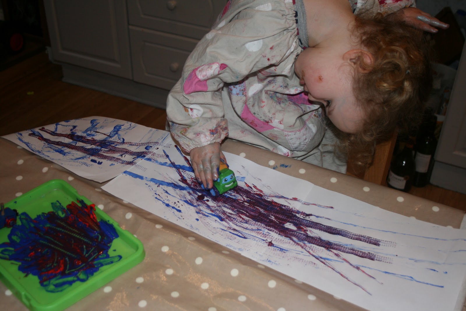Toddler painting with toys