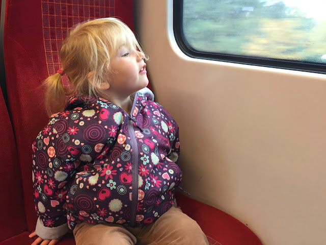 Tin Box Tot looking out the window of a train