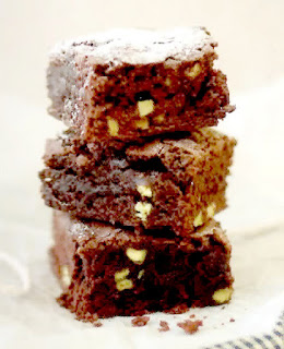 Chocolate Chip Brownies: stack of three brownies containing nuts and chocolate chips dusted with icing sugar
