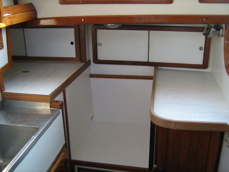 Galley update, installed Corian counters, teak trim and covered cabinet surfaces with white formica