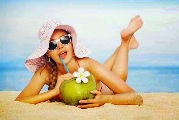 10 beauty secrets of the coconut eating coconut water on beach
