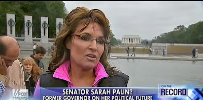 Sporting a drowned varmint wig, pink shirt, and faux patriotism, Sarah Palin answers questions from Greta Van "So Sucks to be interviewing Palin again."