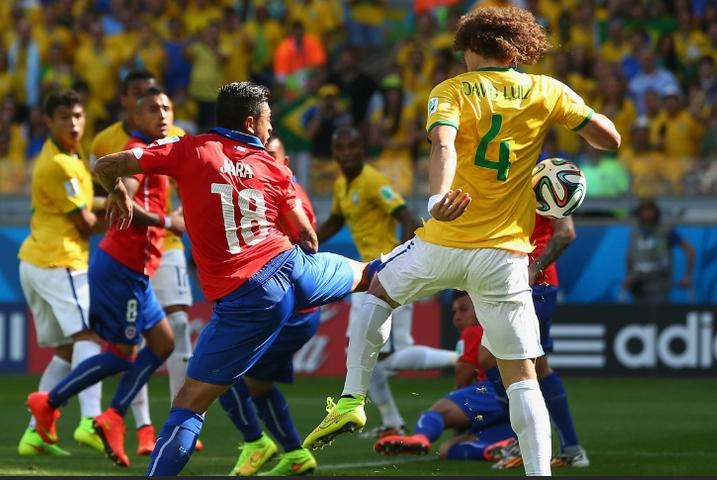 David Luiz e o zagueiro Jara se embolam na área chilena e o Brasil marca primeiro gol (foto: Quinn Rooney/Getty Images)