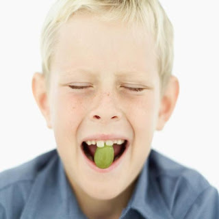Niño comiendo una uva