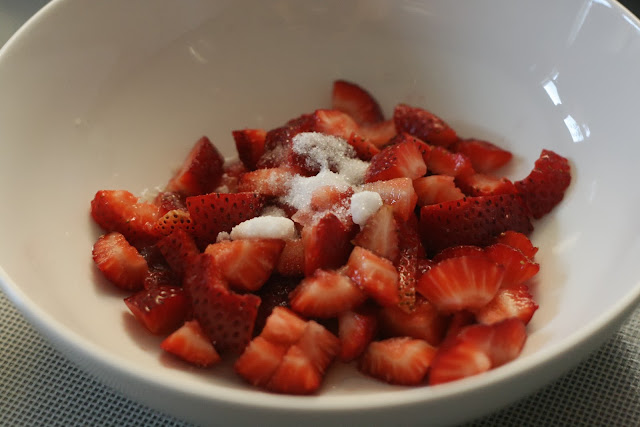 Strawberries macerated with sugar and lemon juice in a bowl. 