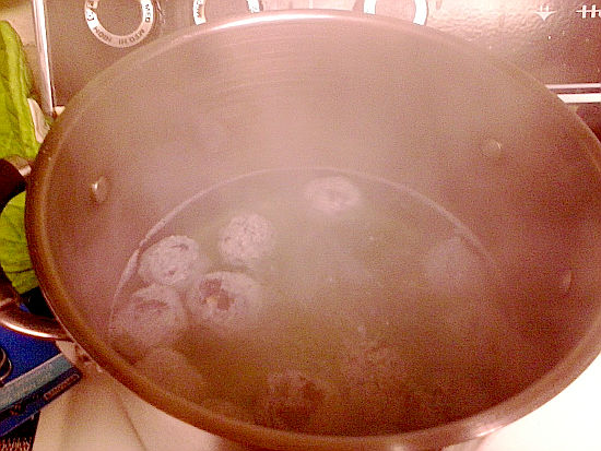 Big pot of boiling water with purple German potato dumplings.