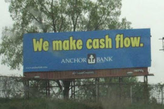 Blue billboard with yellow letters reading We make cash flow, Anchor Bank