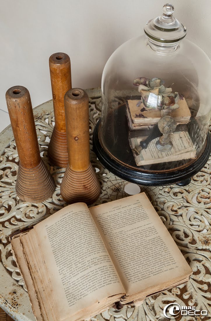 Composition avec des objets chinés dans la maison d'hôtes de charme 'Valdirose' près de Florence : bobines de filature en bois et socle Napoléon III chapeauté d’une cloche en verre 'Chehoma'