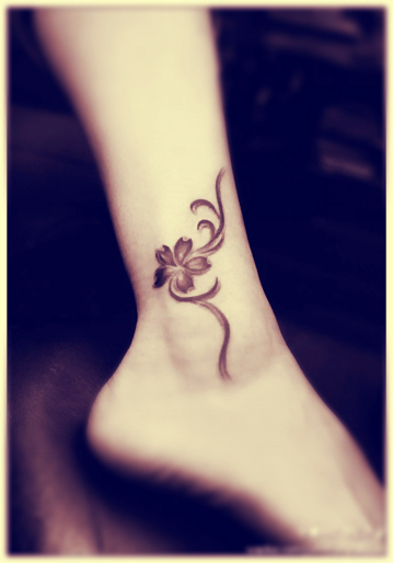 little flower tattoo on the ankle with totem type of stem