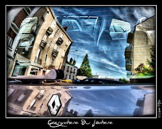 A street scene reflected in the window of a car