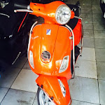 Cửa hàng đang bán xe Piaggio LX 150i đời 2012 màu cam.