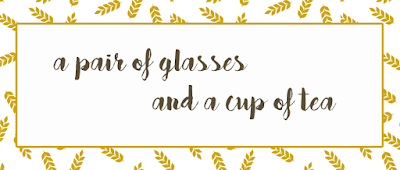 a pair of glasses and a cup of tea