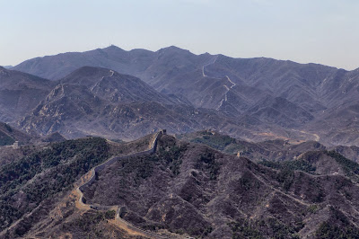 Visitors walk along the Badaling section of the Great Wall of China, some 70 kilometres north of Beijing on April 11, 2012. The Great Wall of China is a series of fortifications made of stone, brick, tamped earth, wood, and other materials generally built along an east-to-west line across the historical northern borders of China in part to protect the Chinese Empire against intrusions by various nomadic groups or military incursions.