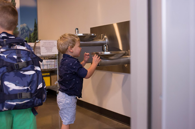boy drinking from water fountains better photos of children, photography tips, mom with a camera, documentary photography, lifestyle photography, family photographer, flower mound photographer, authentic photos of children, jen faith brown photography, children playing, natural smiles, children photography