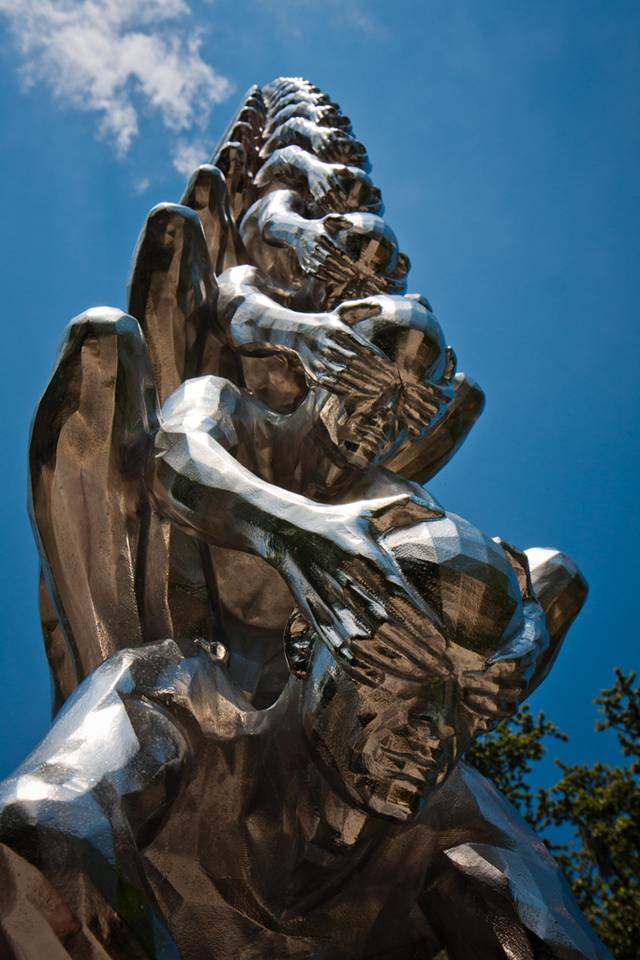 Karma is an intriguing sculptural installation by Korean artist Do Ho Suh that presents countless men sitting atop one another while shielding each other's eyes. Like his Cause & Effect piece, which features a spectacular tornado of figurines, Karma presents figurative sculptures ascending into the sky like a human ladder.