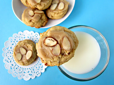 Almond Pudding Cookies with Brown Sugar Frosting on doilie overhead shot with milk glass