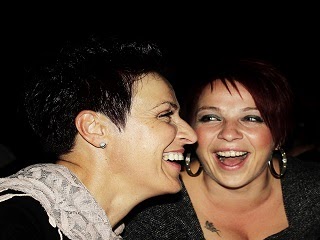 Two women having a conversation and laughing about something. Two women having a conversation and laughing about something.