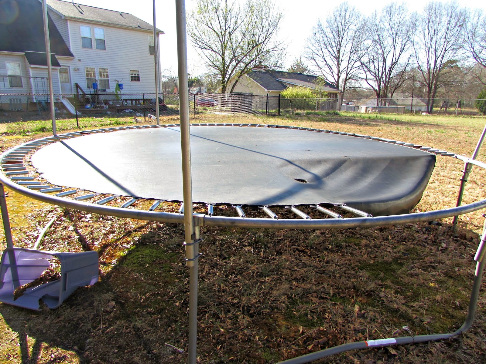 Winnowing Woman turning a trampoline into a chicken run