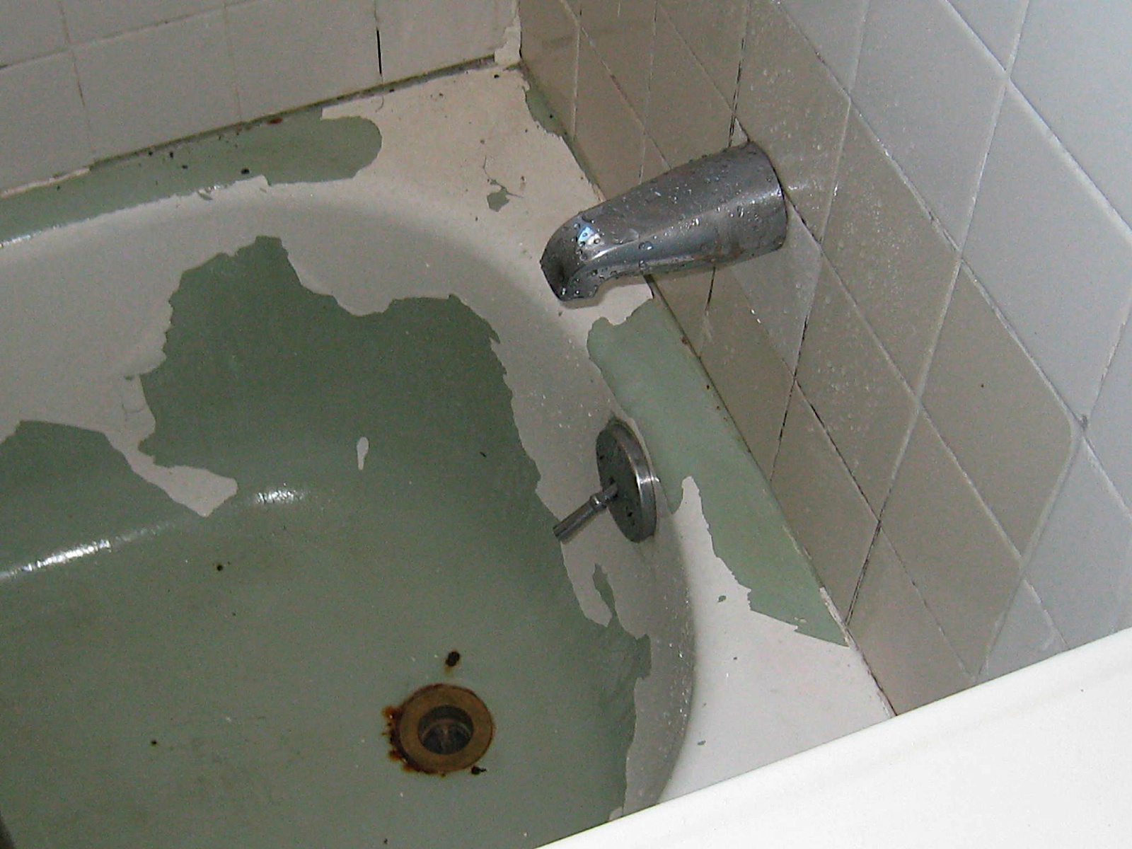 the tub in the condo bathroom needed major work peeling paint and a rusty interior in the bathtub