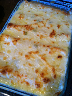 glass cooking pan full of a very cheesy dish that is white chicken enchiladas