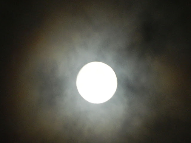 The brilliant moon with the clouds lit around it