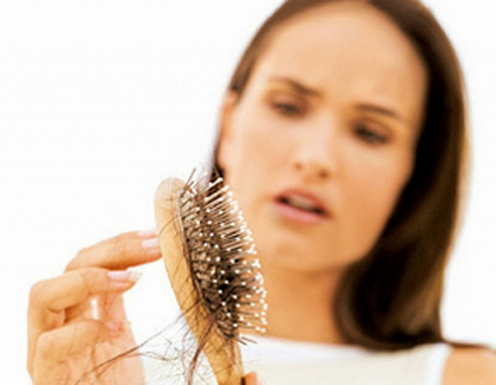 Mulher com escova cheia de fios de cabelo
