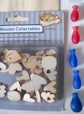 A packet of wooden cutouts in the shape of hearts and clouds and five plastic vase-shaped pieces.