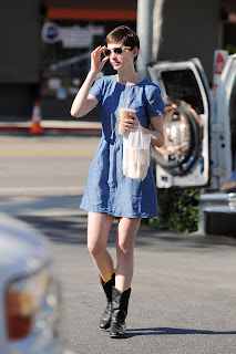 Anne Hathaway adjusting her sunglasses