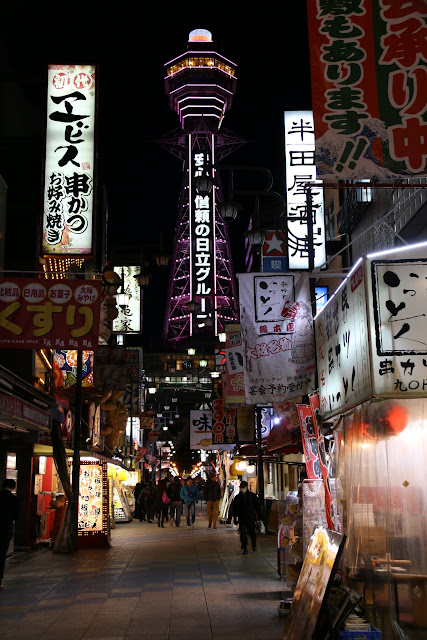Heading to Tsutenkaku Tower while walking along the eateries street of Osaka Shinsekai in Japan Heading to Tsutenkaku Tower while walking along the eateries street of Osaka Shinsekai in Japan