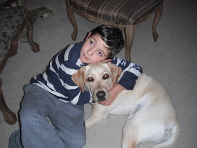 boy hugging yellow Lab