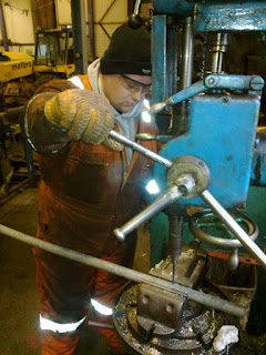 Ryan drilling a pipe for Twizell's ashpan water