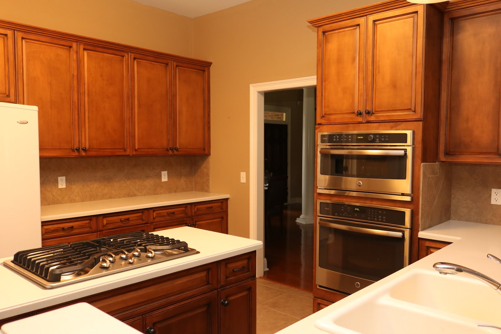 Kitchen with tall/large cabinets; Dining & Great Rooms through doorway (fridge in pic replaced)