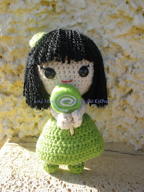 Muñeca realizada a crochet con vestido verde y una piruleta de fieltro