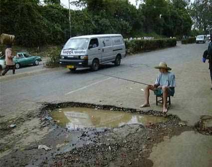 Memancing+Ikan+Besar ditepi jalan dengan memegang sebatang pancing dan merokok..
