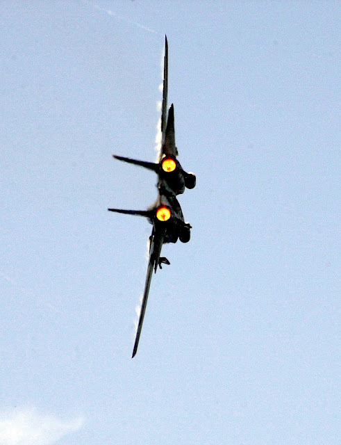 F-14D makes a high-speed turn in full afterburner while passing by the USS Constellation.