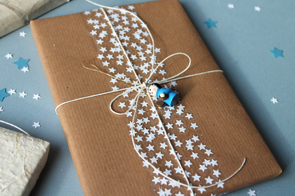 sticky tape with paper stars underneath on top of kraft paper