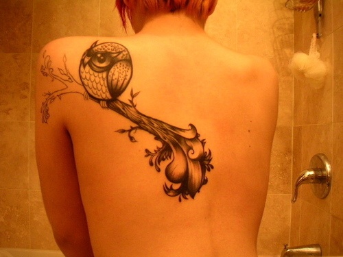 Owl eye tattoo on back body
