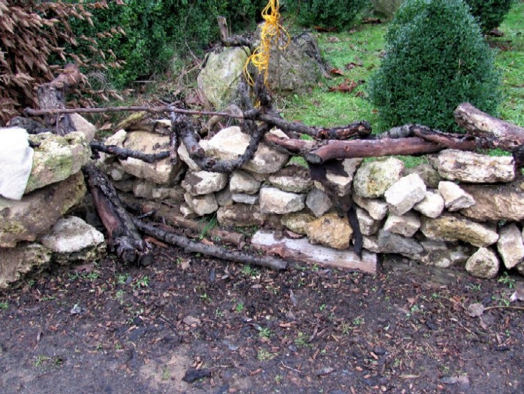Garten anders: eine einfache geschichtete mauer / mit holzästen ...