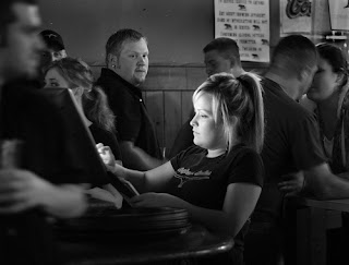 Defenseless woman in bar surrounded by men. Woman in nightclub at with men looking at her.