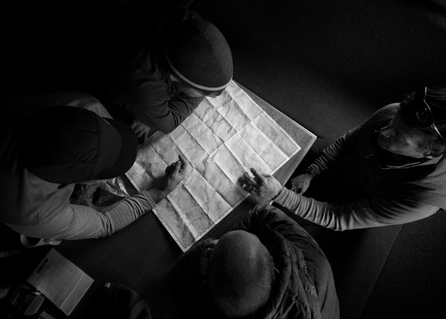 Group looks over a map, choosing the route for the day, Stanley Mitchell Hut, BC.