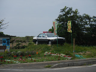 Empty police patrol car on blocks beside the road