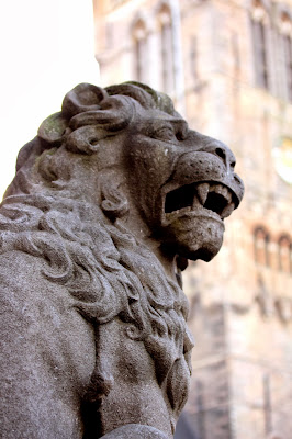 Lion and Belfry A stone lion in The Markt Brugge with the Belfry in the background