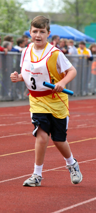 SPECIAL OLYMPICS ATHLETE COMPETES IN THE 4X100 METER RELAY EVENT.