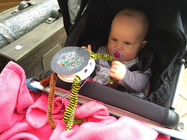 Tin Box Baby playing with a spider made of craft materials