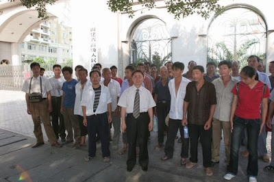 王燦發教授(中)與受害者一起走進法庭，代理1700多人起訴化工廠