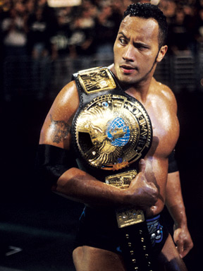 The-Rock-Holding-Champion-Belt-on-Shoulder.jpg