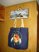 Drum Bag hanging under painting of wolves on barn wood.