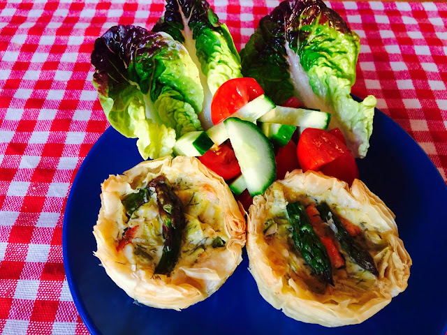 Two smoked salmon and asparagus tartlets on a plate