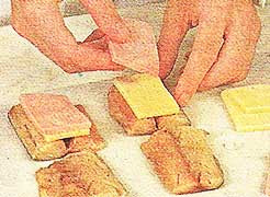 Между кусочками положить ломтик сыра и ветчины соединить зубочисткой